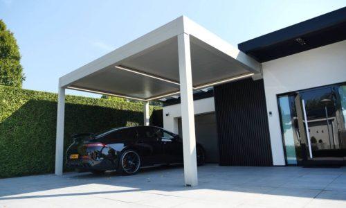 Witte carport onder blauwe lucht met een auto eronder geparkeerd