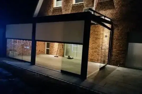 Half geopende zonwerende screen op een veranda in de avond