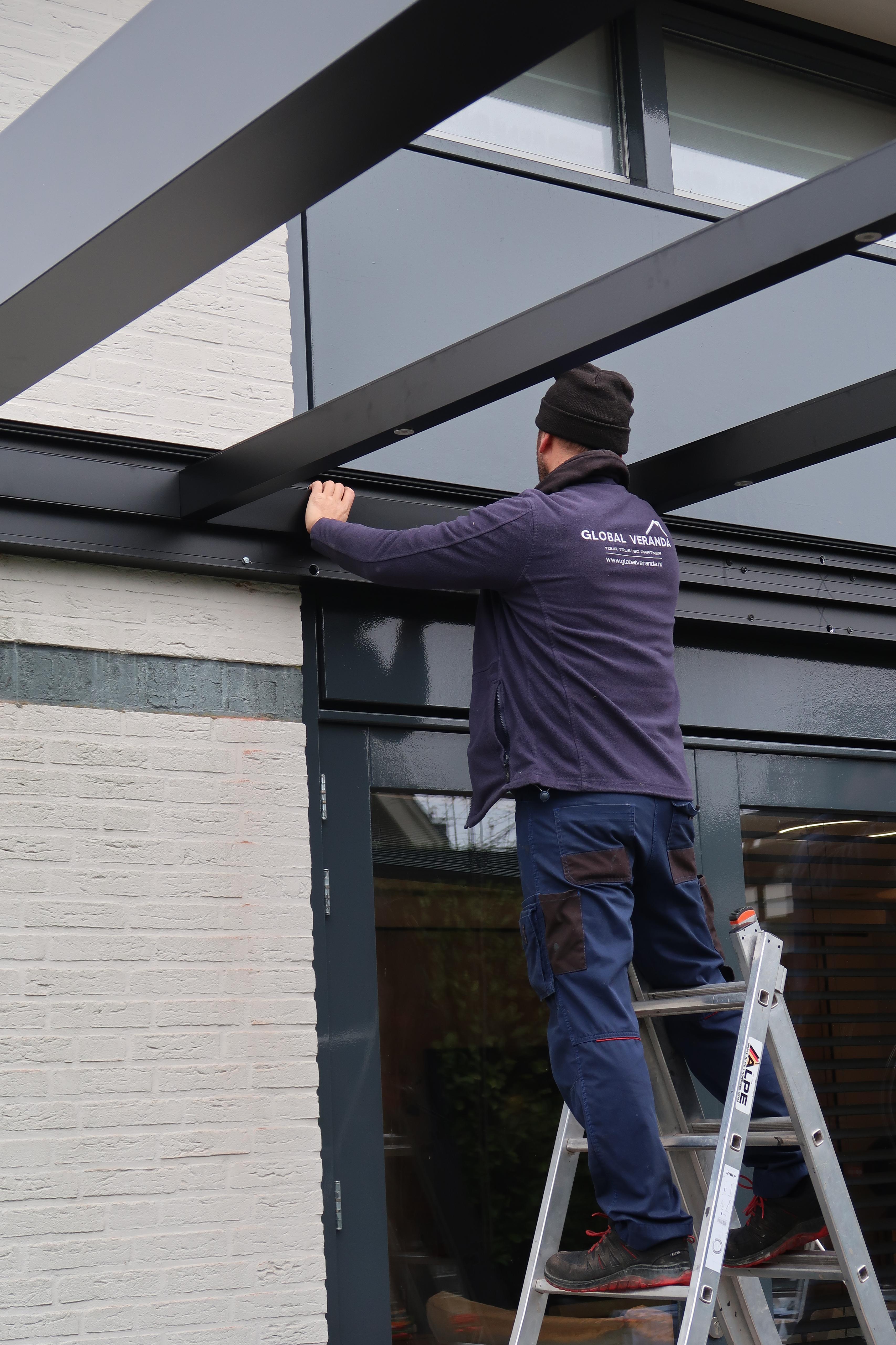 Monteur van Global Veranda bevestigt de dakconstructie