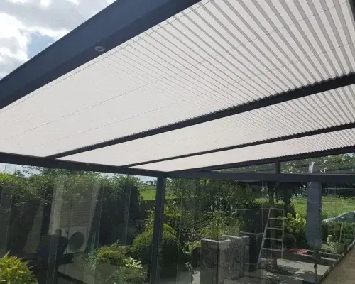 Plisse zonwering op het glazen dak van een overkapping