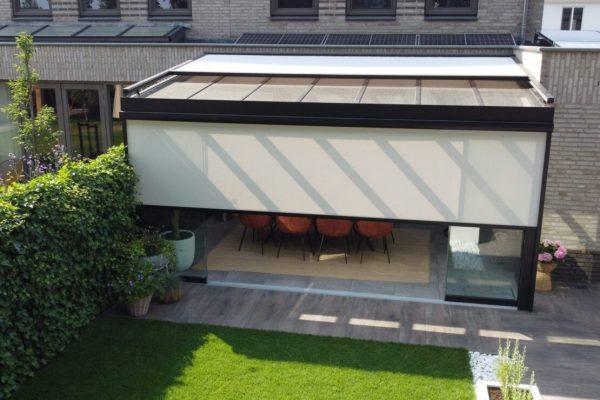 Half gesloten zonwering op een veranda met glazen dak