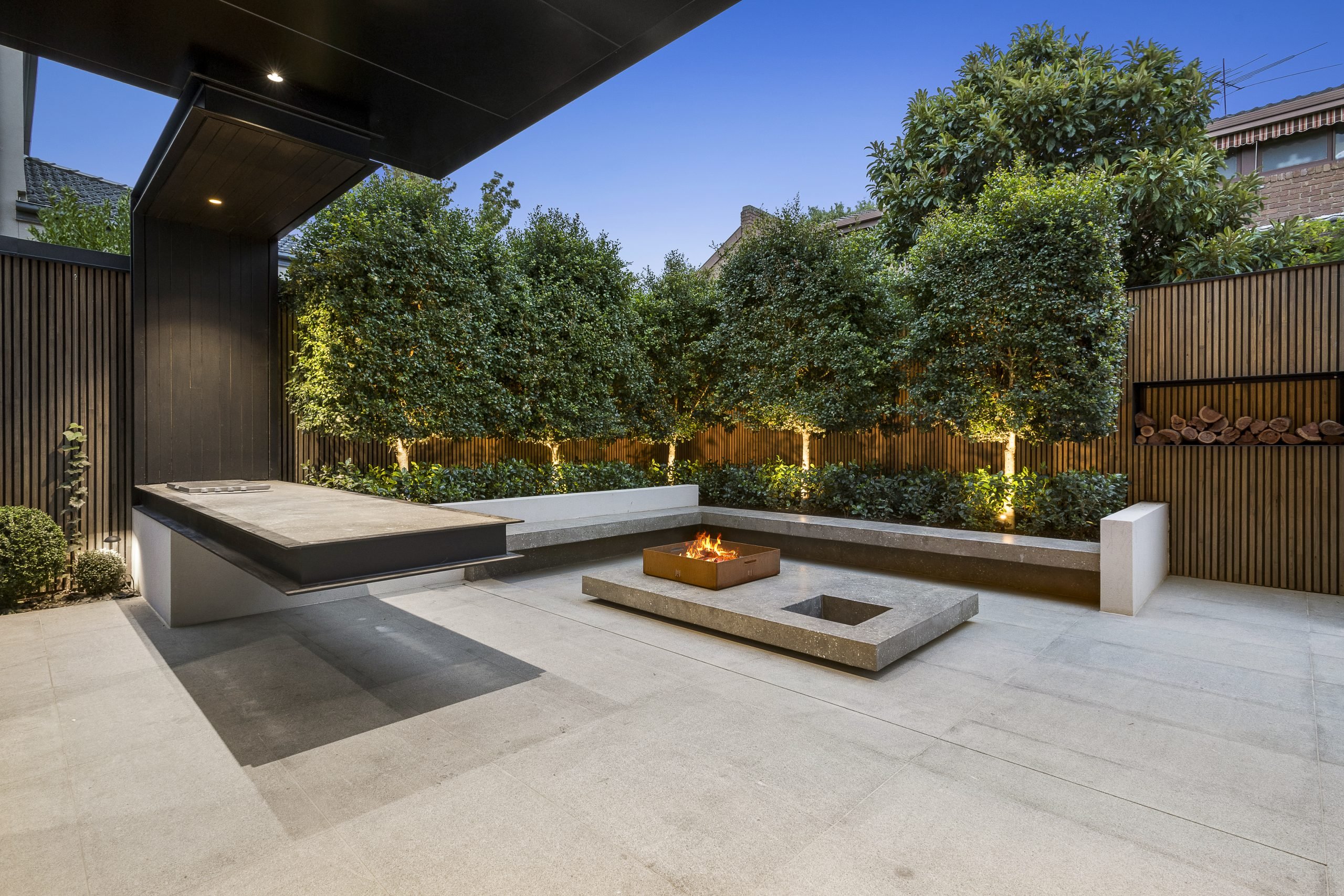 Moderne tuin met vuurplaats in de avond